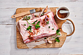 Pork belly with herbs and spices on a wooden board