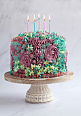 Colourful birthday cake with floral decorations and candles