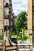 Städtischer Balkon mit blühenden Rosen und Sicht auf Innenhof