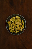 Bowl with green cardamom pods