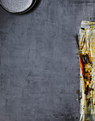 Baking paper with vegetable scraps on a grey background