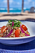 Quinoa salad with cherry tomatoes, coriander and red onions