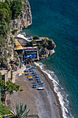 Tourists on the beach of the seaside resort town of Positano, Amalfi Coast, Italy.