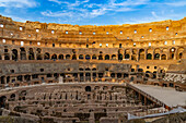 Interior of the Roman Colosseum or Flavian Amphitheater with golden sunset light in Rome, Italy. The tunnels under the floor of the arena were called hypogeum.