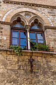 Moorish arch windows in a building on the Via San Giovanni in the walled town of San Gimignano, Italy.