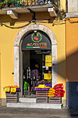 A grocer's shop with an arched doorframe of Carrara marble in Carrara, Italy.