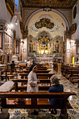 A nun ministers to a worshipper in the Church of Santa Maria delle Grazie in Sorrento, Italy.