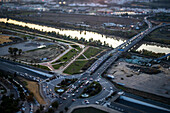 Tilt-shift view captures evening light over the Guadalquivir, showing traffic on A49 as the day transitions to night.