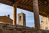 The campanile or bell tower of the Collegiata di Santa Maria Assunta in the medieval city of Gimignano, Italy. Seen from the gallery of the Palazzo Comunale.