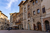 Mittelalterliche Gebäude rund um die Piazza della Cisterna in der ummauerten Stadt San Gimignano, Italien.