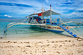 Traditional boats moored off a tiny tropical island beach in the Philippines Kalanggaman island, Malapascua, Cebu, Philippines