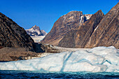 Skjoldungen Fjord. Large iceberg in scenic fjord surrounded by snow-capped mountains, Southeast coast, Greenland