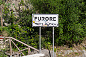 Road sign for the commune of Furore on the Amalfi Coast in Italy. Vandalized with stickers.