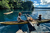 Residents of Vitu Islands in their traditional dugout canoes, Garove Island, Johann Albrecht Harbour, Papua New Guinea