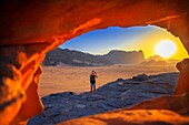 Tourist girl taken pictures over the red sands of the desert of Wadi Rum in the sunset time, Jordan