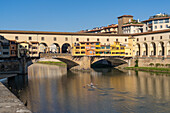 A rower in a scull at the Ponte Vecchio, a medieval stone arch bridge over the Arno in Florence, Italy.