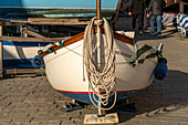 A boat out of the water with a painter on the bow by the harbor in Riomaggiore, Cinque Terre, Italy.