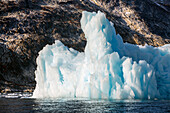 Kangerlussuaq Fjord. Large iceberg in scenic fjord surrounded by snow-capped mountains, Southeast coast, Greenland