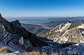 Blick über die Marmorbrüche, die Stadt Carrara und das Ligurische Meer von den Apuanischen Alpen in Italien.