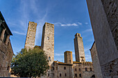 The twin Salvucci Towers in the Piazza della Erbe in the medieval city of San Gimignano, Italy. At right are the Torre Chigi and the Torre Rognosa.