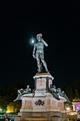 A bronze cast of the David statue with the moon behind on the Piazzale Michelangelo in Florence, Italy.