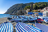 Boats with striped covers on the beach in off peak season at Monterosso al Mare, Cinque Terre, Italy.