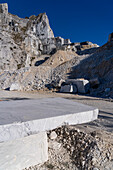 A Carrara marble bench for sitting on during the quarry tour in Fantiscritti. Carrara, Italy. A quarry is behind.