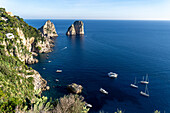 Boats and the Farallon Islands or faraglioni, sea stacks off the coast of the island of Capri, Italy.