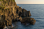 A walkway on the rocks along the water of the Lingurian Sea by Riomaggiore, Cinque Terre, Italy.