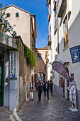 Touristen spazieren auf der schmalen Via Antonino Sersale im historischen Zentrum von Sorrento, Italien.