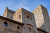 The two Towers of Ardingheili on the Piazza della Cisterna in the medieval city of San Gimignano, Italy. Behind is the top of the Torre Grossa, the tallest tower in the city.