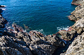 The rocky cliffs above the harbor of the fishing village of Manarola, Cinque Terre, Italy.