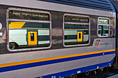 Another train reflected in the windows of a Trenitalia Pop regional passenger train at La Spezia, Italy. The Pop is a Coradia Stream built by Alstom.