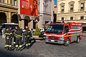 A crew of fireman with their fire truck in Republic Square in Florence, Italy.