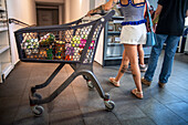 Poor and vulnerable families collecting donated products in the supermarket Rebost Solidari de Gracia, Gracia neighborhood, Barcelona, Spain, Europe. The Rebost Solidari de Gracia is a distributor entity of the Food Bank in its Sec, SERMA (fresh fruit and vegetables), cold chain (frozen and refrigerated products) and FEGA (products received from the EU) programs. An efficient management of all the food surpluses generated by the neighborhood (markets, supermarkets, shops, companies, restaurants, school canteens and others) is an important enough objective in itself, both for its use in the nei