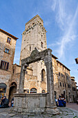 The Piazza della Cisterna & the Devil's Tower or Torre del Diavolo in the medieval city of San Gimignano, Italy.