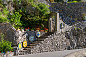 Large, colorful ceramic tabletops decorate a stone staircase at a ceramic shop on the Amalfi Coast of Italy.