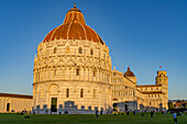 Baptistery of St. John, the Pisa Cathedral and Leaning Tower in the Piazza dei Miracoli in Pisa, Italy. The top half of the baptistery is Gothic style, while the lower half is Romanesque.