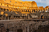 Interior of the Roman Colosseum or Flavian Amphitheater with golden sunset light in Rome, Italy. The tunnels under the floor of the arena were called hypogeum.