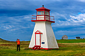 Iles de la Madeleine Cape Alright lighthouse on a cliff overlooking a sandy beach in the Iles de la Madeleine, Quebec, Canada