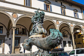 Fountain statue of a sea monster on the Piazza Santissima Annunciata, Florence, Italy. Behind is the Loggiato dei Serviti, now a hotel.