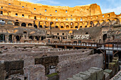 Interior of the Roman Colosseum or Flavian Amphitheater with golden sunset light in Rome, Italy. The tunnels under the floor of the arena were called hypogeum.