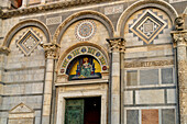 Gold mosaic of the Virgin Mary over the left portal of the west facade of the Duomo of Pisa. Pisa, Italy. Created by Giuseppe Modena da Lucca.