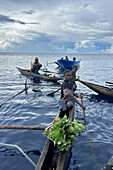 Residents of New Hanover island in their traditional dugout canoes, New Ireland province, Papua New Guinea