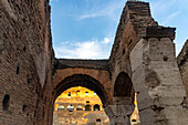 View through an arch into the interior of the ancient Colosseum in Rome, Italy.