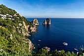 Boats and the Farallon Islands or faraglioni, sea stacks off the coast of the island of Capri, Italy.