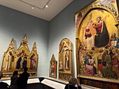 Visitors viewing Renaissance paintings in an exhibit hall in the Accademia Gallery in Florence, Italy. These paintings are in the Giovanni da Milano and Orcagna Room in the Museum.