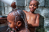 Children playing and bathing in precarious conditions in the plage de Ti Mouillage beach in Cayes-de-Jacmel, Cayes de Jacmel, Jacmel, Haiti.