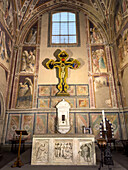 Painted crucifix in the Castellani Chapel in the Basilica of Santa Croce in Florence, Italy. The crucifix was painted in 1380 by Pietro Nelli in conjunction with Niccolo di Pietro Gerini. The reliefs on the front of the altar are from the late 13th Century. The marble tabernacle was carved by Mino da Fiesole about 1483. Frescos painted by Agnolo Gaddi and his workshop.