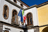 Flags on the front of a restaurant on the Piazza Sant'Antonino in the historic center of Sorrento, Italy.